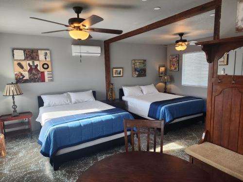 een slaapkamer met twee bedden en een plafondventilator bij Sunrise Springs in Pahrump