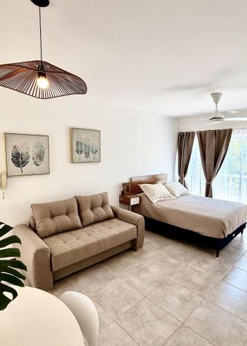 un salon avec deux lits et un canapé dans l'établissement Río Breve - Departamento moderno en Zona Norte, à Rosario