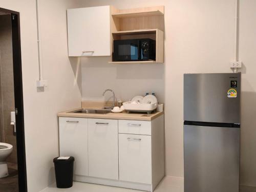 een kleine keuken met een roestvrijstalen koelkast bij Le Wadee Residence in Bang Tao Beach