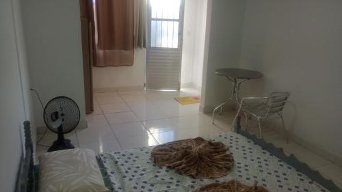 een kamer met een bed, een ventilator en een vloer bij Pousada Enseada do Coqueiro in Guarapari