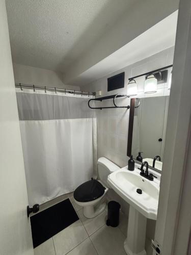 a white bathroom with a sink and a toilet at Son de Metro Apartment - Condado Beach & Pool, Walk to Ocean in San Juan