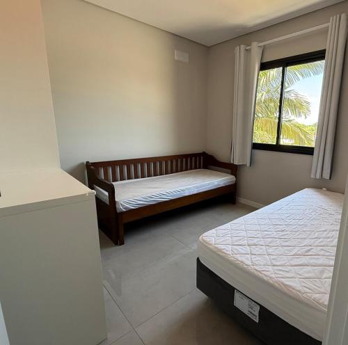 une chambre avec deux lits et une fenêtre dans l'établissement Apartamento Ju & Mar, à Itapoá