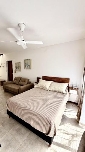 une chambre avec un grand lit et un canapé dans l'établissement Río Breve - Departamento moderno en Zona Norte, à Rosario
