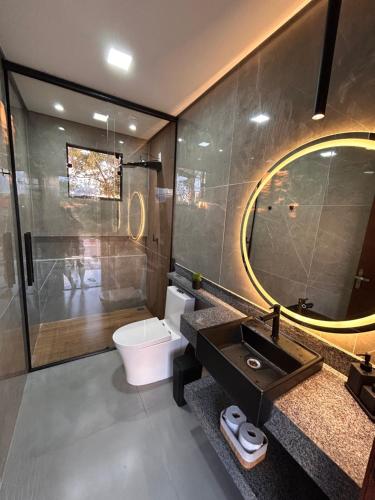 un bagno con lavandino, WC e specchio di Casa Firenze a Rio Manso