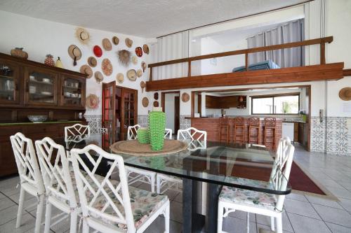 a dining room with a glass table and white chairs at Sítio Do Louro Villa in São Martinho do Porto
