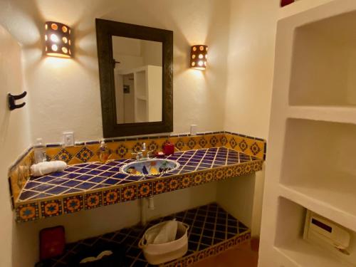a bathroom with a sink and a mirror at Sol - Casa MoJo's charming 1BR, kitchen, pool in Sayulita