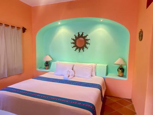 a bedroom with a large bed with a clock on the wall at Sol - Casa MoJo's charming 1BR, kitchen, pool in Sayulita