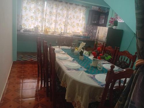 een lange tafel met stoelen en een witte tafelkleed bij Shantee Residence in Trou dʼ Eau Douce
