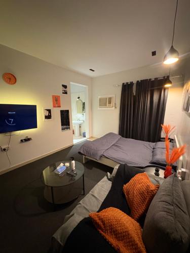 een woonkamer met een bed en een bank bij استديو بطابع هادي in Al Khobar