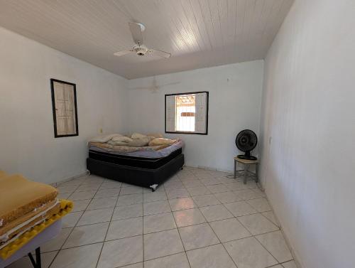 una camera da letto con un letto e un ventilatore a soffitto di Casa Temporada Refúgio das Ondas a Guriri