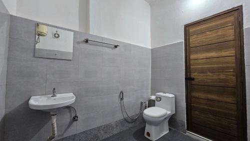 a bathroom with a toilet and a sink at Vayuvana Heritage Organic Farm Resort in Panamaram