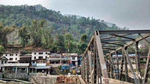 een brug over een stad met een berg op de achtergrond bij Hotel evergreen lodge in Kāskī