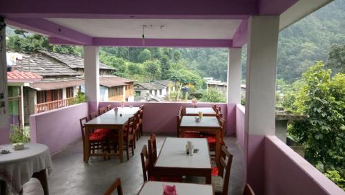 een restaurant met tafels en stoelen op een balkon bij Hotel evergreen lodge in Kāskī