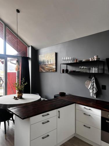 a kitchen with a white counter and a table at Eidebua in Haug
