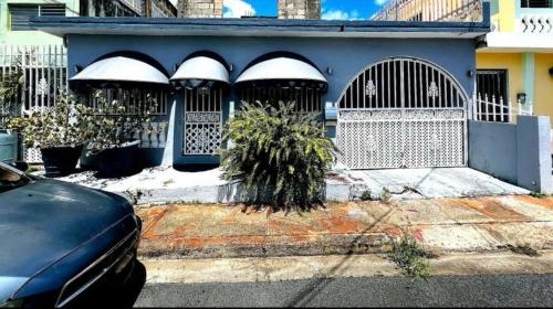 a blue house with gates and a plant in front of it at Tulli Private house in San Juan in San Juan