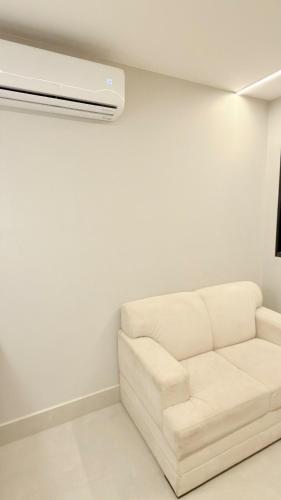 a living room with a white couch and a air conditioner at Flat Premium bairro nobre in Imperatriz