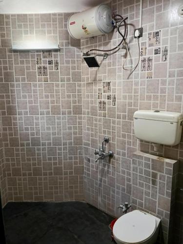 a bathroom with a toilet and a water tank at Rajlok Resort in Mulshi