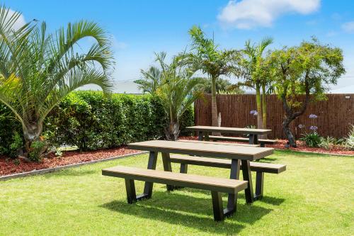 two picnic tables sitting on the grass in a garden at Baywatch Retreat Augusta in Augusta