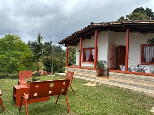 een huis met een tafel en stoelen ervoor bij Finca Vista Verde Guarne in Guarne