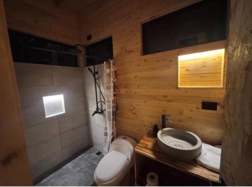 a wooden bathroom with a sink and a toilet at Boheme Cabin in Medellín