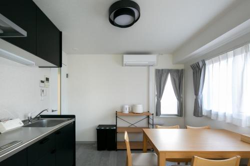 a kitchen with a wooden table and a dining room at trive osu monzencho 601 最大5名宿泊可能 大須商店街徒歩スグ in Nagoya