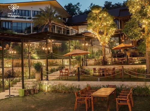 een restaurant met tafels en stoelen voor een gebouw bij Valley De Mango Hue in Thôn Châu Chữ