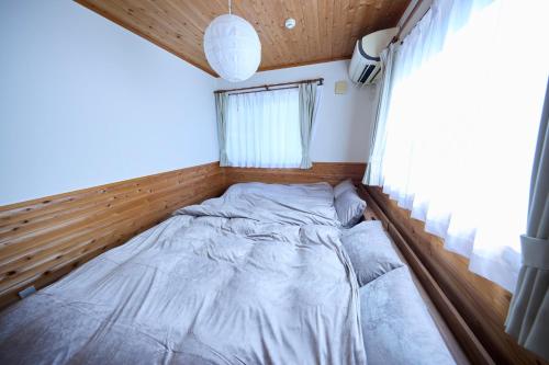 een bed in de hoek van een kamer met een raam bij BLUEBAY TERRACE okutama in Okutama