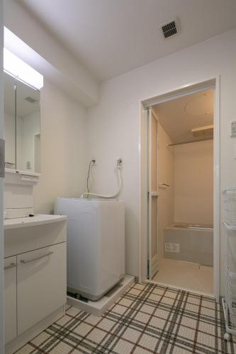 a white bathroom with a sink and a shower at trive osu monzencho 702 最大5名宿泊可能 大須商店街徒歩スグ in Nagoya