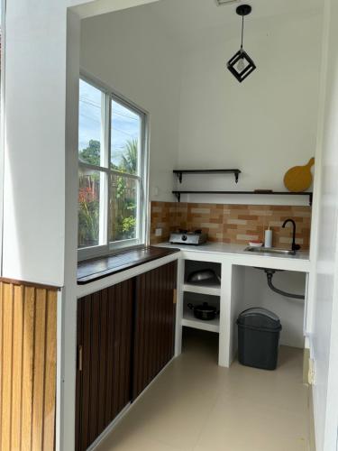 een keuken met een spoelbak en een raam bij Ivorys Guesthouse in Panglao