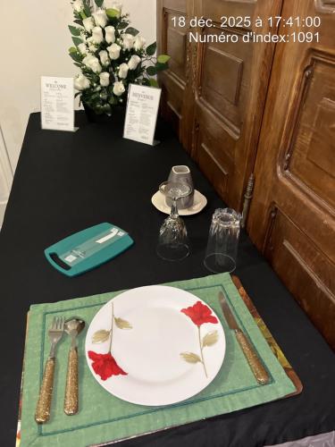 einen Tisch mit einem Teller und Küchenutensilien auf dem Tisch in der Unterkunft Une expérience artistique in Villeneuve-Saint-Georges