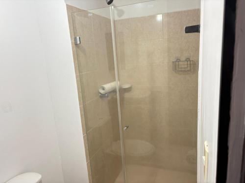 a glass shower stall with a toilet in a bathroom at apta estudio oronegro amanecer in Armenia