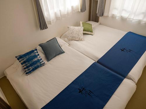 a bed with pillows on it in a room at 桜の川70-41 稲荷町駅 近上野-浅草 2-8人丨 Inaricho Station, Near Ueno, Asakusa 2-8 people in Tokyo