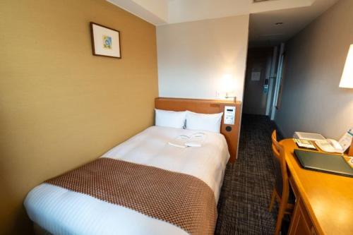 a hotel room with a bed and a desk at Toshi Center Hotel in Tokyo