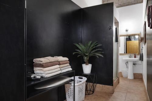 a bathroom with black walls and a sink and towels at St. Vincent Lofts in Los Angeles