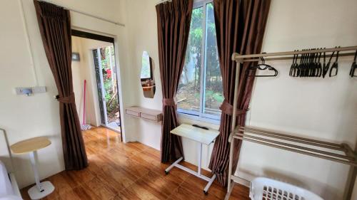 a room with curtains and a table and a window at Casa Srithanu in Koh Phangan