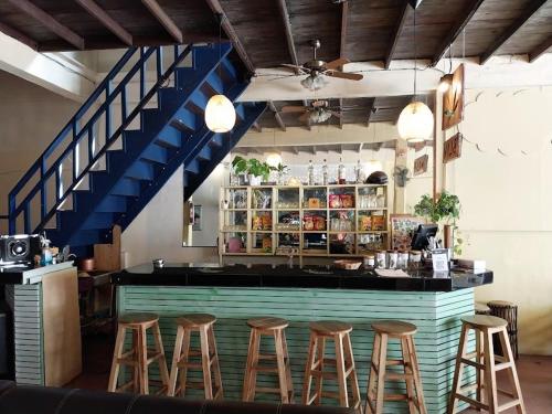 een bar met krukken in een kamer met een trap bij 90 Hostel in Ban Nua