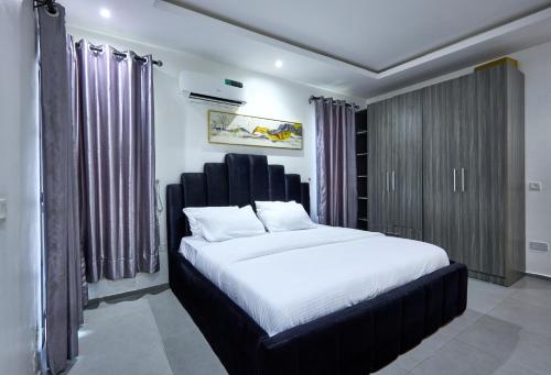a bedroom with a large bed with a black headboard at The Haven in Lekki