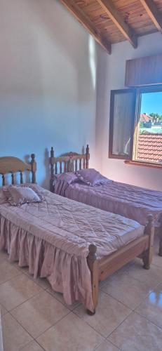 two twin beds in a room with a window at Duplex Playa in Santa Clara del Mar