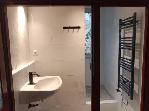 een witte badkamer met een wastafel en een raam bij Lounge-Style-Hostel in Sankt Veit an der Glan