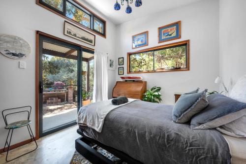 a bedroom with a bed and a sliding glass door at Hyams Reach Retreat in Erowal Bay