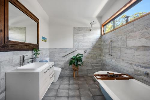 a bathroom with a tub and a toilet and a sink at Hyams Reach Retreat in Erowal Bay