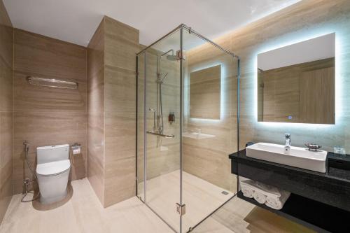 un bagno con doccia, WC e lavandino di Sun River Hotel a Da Nang