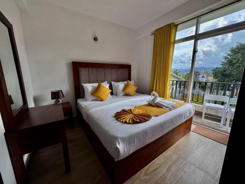 een slaapkamer met een bed en een raam met uitzicht bij Green Mount View Two Bed Room Apartment in Nuwara Eliya