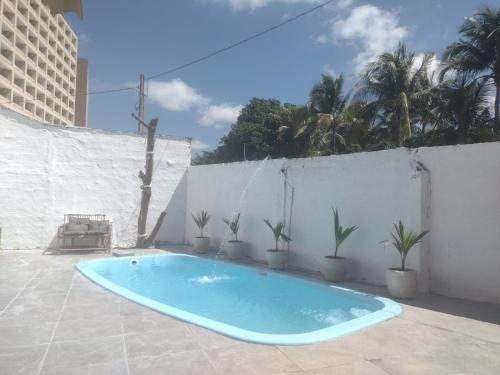 a swimming pool on a patio with potted plants at Casa de Temporada 5 Estrelas in Olímpia