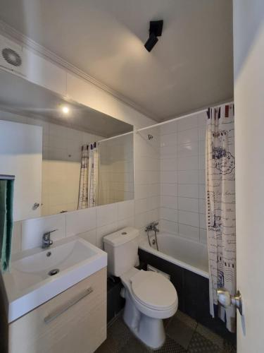 a bathroom with a toilet and a sink and a tub at Departamento full equipado in Coquimbo