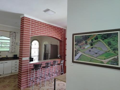 een keuken met een bakstenen muur met een schilderij aan de muur bij Sítio dos Rodrigues in Lindóia