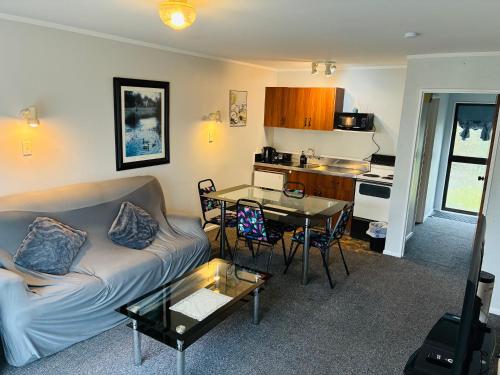 een woonkamer met een bank en een tafel bij Awatea Park Motel in Palmerston North