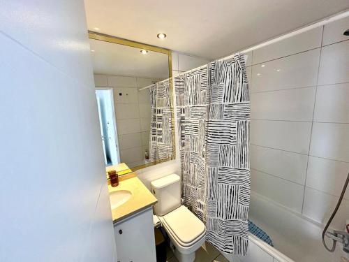 a bathroom with a toilet and a shower curtain at Incredible Ocean View in Viña del Mar