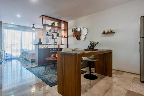 a living room with a desk and a bedroom at Playa Azul Studio - Coco Beach I in Playa del Carmen