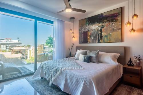 a bedroom with a bed and a large window at Playa Azul Studio - Coco Beach I in Playa del Carmen